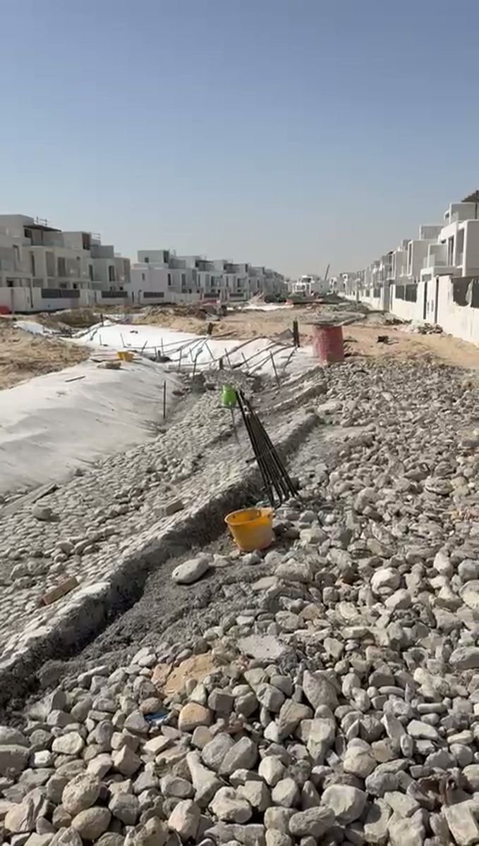 Completed erosion-control channel with geotextile and rip-rap at a Dubai villa community